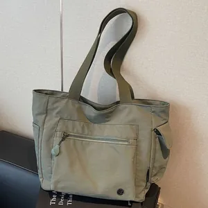 Minimalist military green nylon tote bag with large front pocket for daily commuting