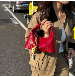 Detailed view of red woven hobo bag with a multicolor wooden bead tassel pendant charm