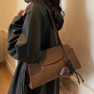 Chic brown lychee leather shoulder tote bag for women with a mini charm on the side