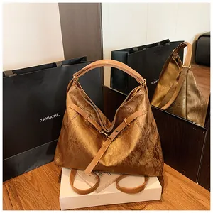 Detail showing the metallic brown texture and wide strap of the large tote bag