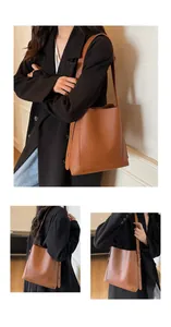 Detailed view of caramel brown bucket bag in textured leather with thick shoulder strap