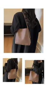 Detailed views of brown pebble leather bucket bag with long shoulder strap for daily commuting