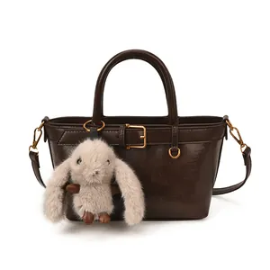Sac à main vintage marron avec pendentif lapin en peluche et garnitures dorées