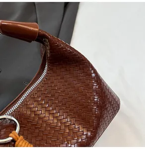 Macro shot of dark brown hand-woven leather texture and silver metal zipper detail