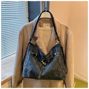 Close-up of black vintage textured tote bag with metal buckle and leather strap detail