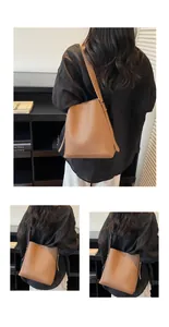 Detail view of brown pebbled leather bucket bag showing soft texture and shoulder strap