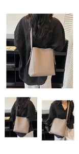 Detail of taupe lychee pattern leather bucket bag showing fine texture and side straps