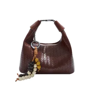 Dark brown woven leather handbag with integrated handle and colorful beaded tassel charm