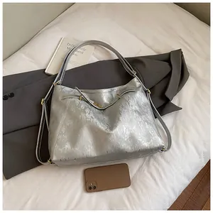 Detail of silver metallic tote bag with textured faux leather and golden hardware