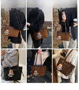 Photos de modèle d'un grand sac cabas avec breloque ours et finition mate chic