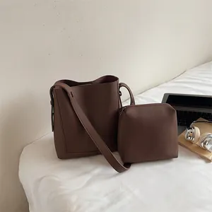 Detailed view of the dark brown lychee pattern leather bucket bag and matching pouch