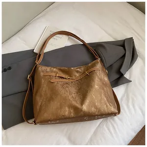 Close-up of metallic bronze tote bag texture with leather straps and golden hardware