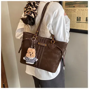 Détail du grand sac cabas marron foncé mat avec coutures et charmant pendentif ours