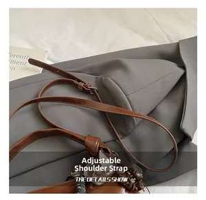 Detail of adjustable leather strap with silver buckle on a dark brown Boston bag