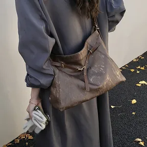 Brown vintage leather tote bag for women with gold buckle detail shown on shoulder