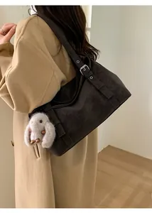 Détail du cabas en daim marron foncé avec sangle réglable et breloque lapin en peluche