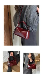 Detailed close-up of dark red glossy Boston bag with silver hardware and woven strap detail