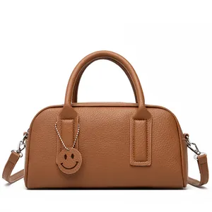 Classic brown Boston bag in lychee texture leather with a removable strap and smile pendant