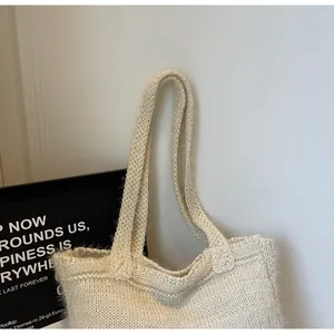 Vue détaillée de la texture tricotée crème et de la poignée souple intégrée du sac