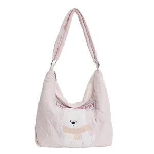 Detail of pink quilted tote bag with heart patterns and lucky puppy plush embroidery