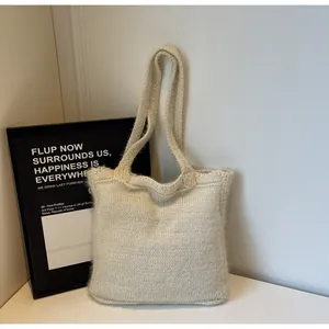 Gros plan du sac cabas en tricot blanc crème montrant la texture douce et minimaliste