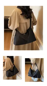 Detail of black nylon crescent tote bag showing the metallic twist lock and texture