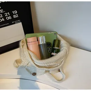 Grand sac cabas en maille crème avec bouton en bois montrant sa grande capacité