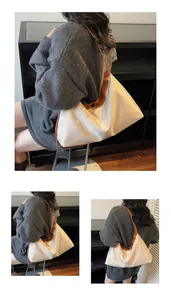 Detail of minimalist hobo tote bag in beige nylon with brown leather straps and silver buckle