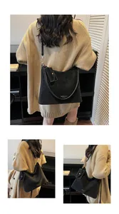 Detail of black matte suede tote bag with side pouch and retro commuter style design