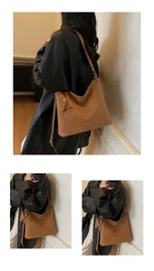 Detailed close-up of brown suede tote bag featuring Minxiou logo and side envelope pouch
