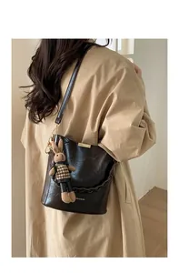 Detail of vintage dark brown bucket bag with gold hardware and rabbit charm