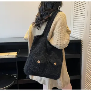 Détail du grand sac cabas en tweed noir avec poches frontales et boutons en bois