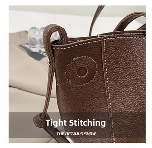 Detail of dark brown litchi grain leather tote with fine white contrast stitching