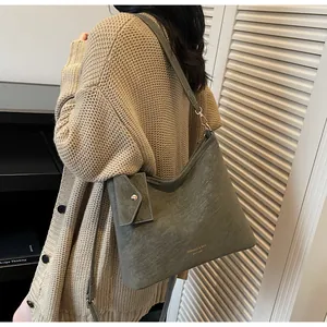 Detail of grey-green tote bag with matching pouch in soft matte textured leather finish