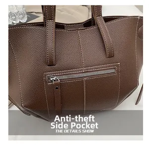 Detail of coffee brown lychee leather tote showing the anti-theft side zip pocket