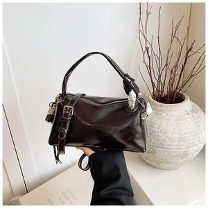 Close-up of vintage glossy oil-wax leather texture on large capacity crossbody bag