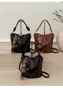 Detail of vintage bucket bags with braided handles and a plush bunny charm accessory