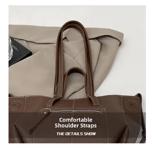 Detail of lychee pattern leather tote bag with reinforced straps and sturdy stitching