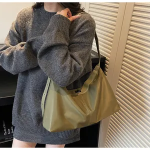 Detail of avocado green nylon tote bag with white stitching and silver square buckle lock