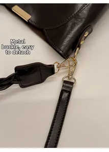 Close-up of golden hardware clasp and detachable woven strap on a dark brown bucket bag