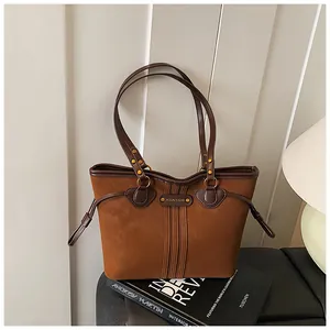 Vue détaillée du sac cabas marron avec logo métallique vintage et lanières décoratives