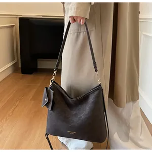 Detail of dark brown hobo shoulder bag with logo and detachable small coin purse