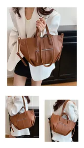 Detail view of large brown lychee texture tote bag featuring metallic zipper and folding sides
