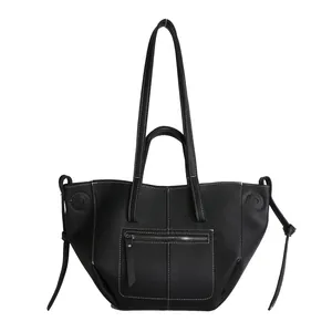 Detail of large black pebbled tote bag with white contrast stitching and side drawstrings