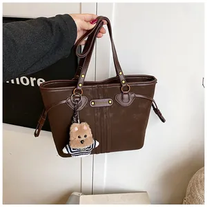 Détail du sac cabas marron café avec texture mate et pendentif d'ours en peluche doux