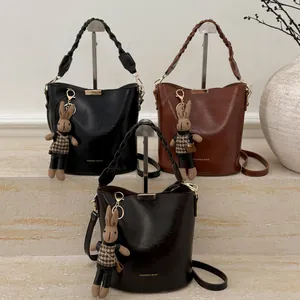 Three vintage PU leather bucket bags with woven handles and rabbit charms on steps