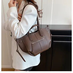 Detailed view of brown litchi pattern leather tote bag with exterior zipper pocket