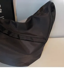 Detail of waterproof black nylon fabric texture and zipper on the stylish crossbody bag