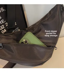 Close-up of black nylon crossbody bag featuring a front zipper pocket for easy storage