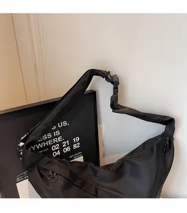 Detail of durable black nylon shoulder bag featuring dual zippers and heavy-duty buckle